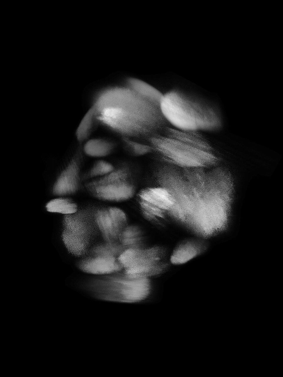 Abstrakte schwarz-weiße Komposition mit sanft verschwommenen Formen auf schwarzem Hintergrund.