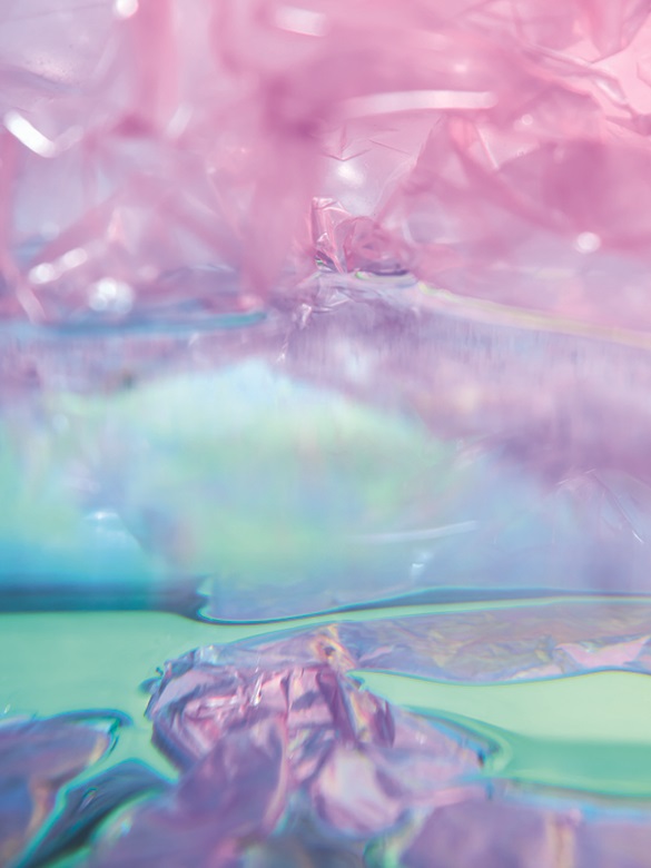 Colorful, shimmering plastic material in soft pink and purple tones, combined with reflective water.