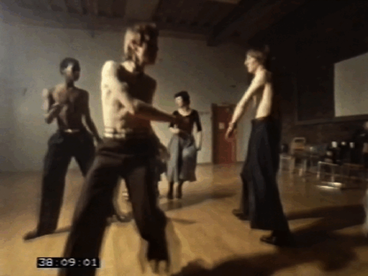 Tanzende Gruppe von vier Personen auf einem Holzfußboden, mit energetischen Bewegungen und kreativem Ausdruck.