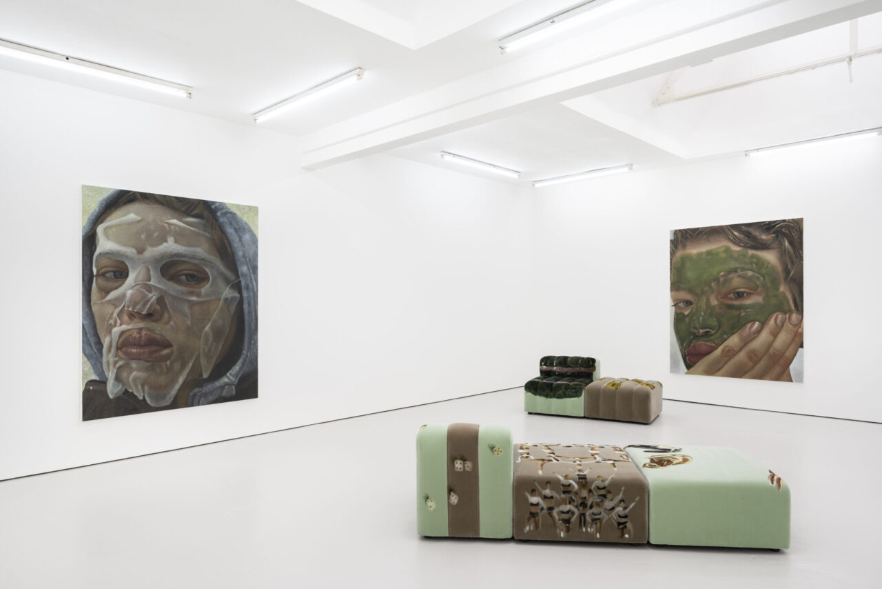 Moderne Kunstgalerie mit zwei großen Gemälden und einer skulpturalen Couch in minimalistischer Umgebung.