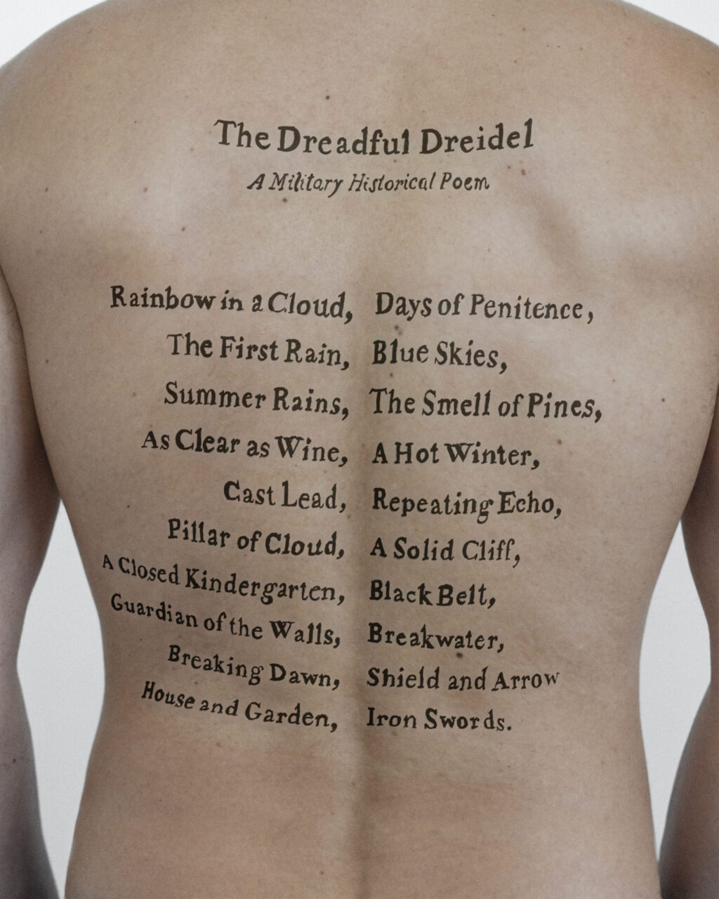 Tattoo titled "The Dreadful Dreidel" with poetic lines, placed on a back.