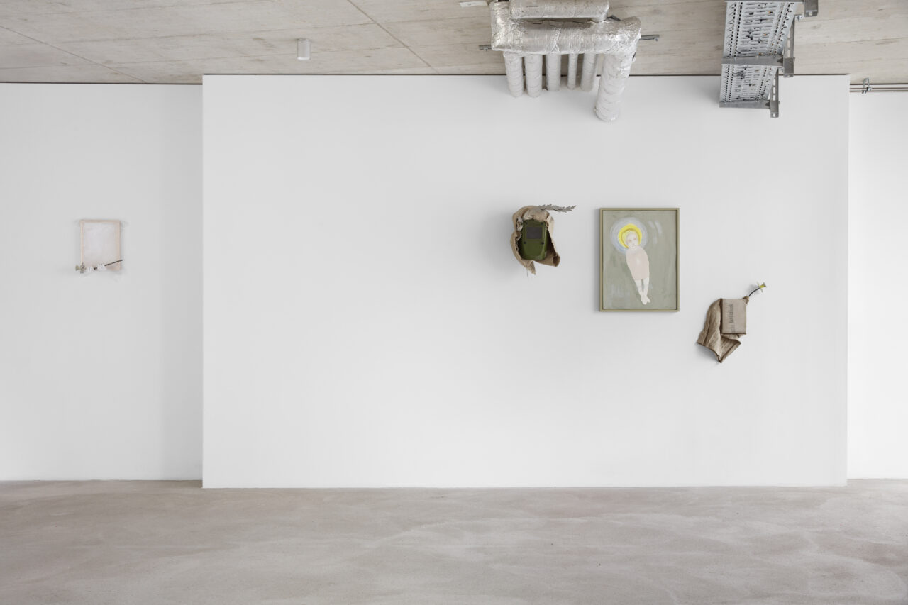 Minimalistische Innenansicht mit weißer Wand, Kunstwerken und glattem Boden.