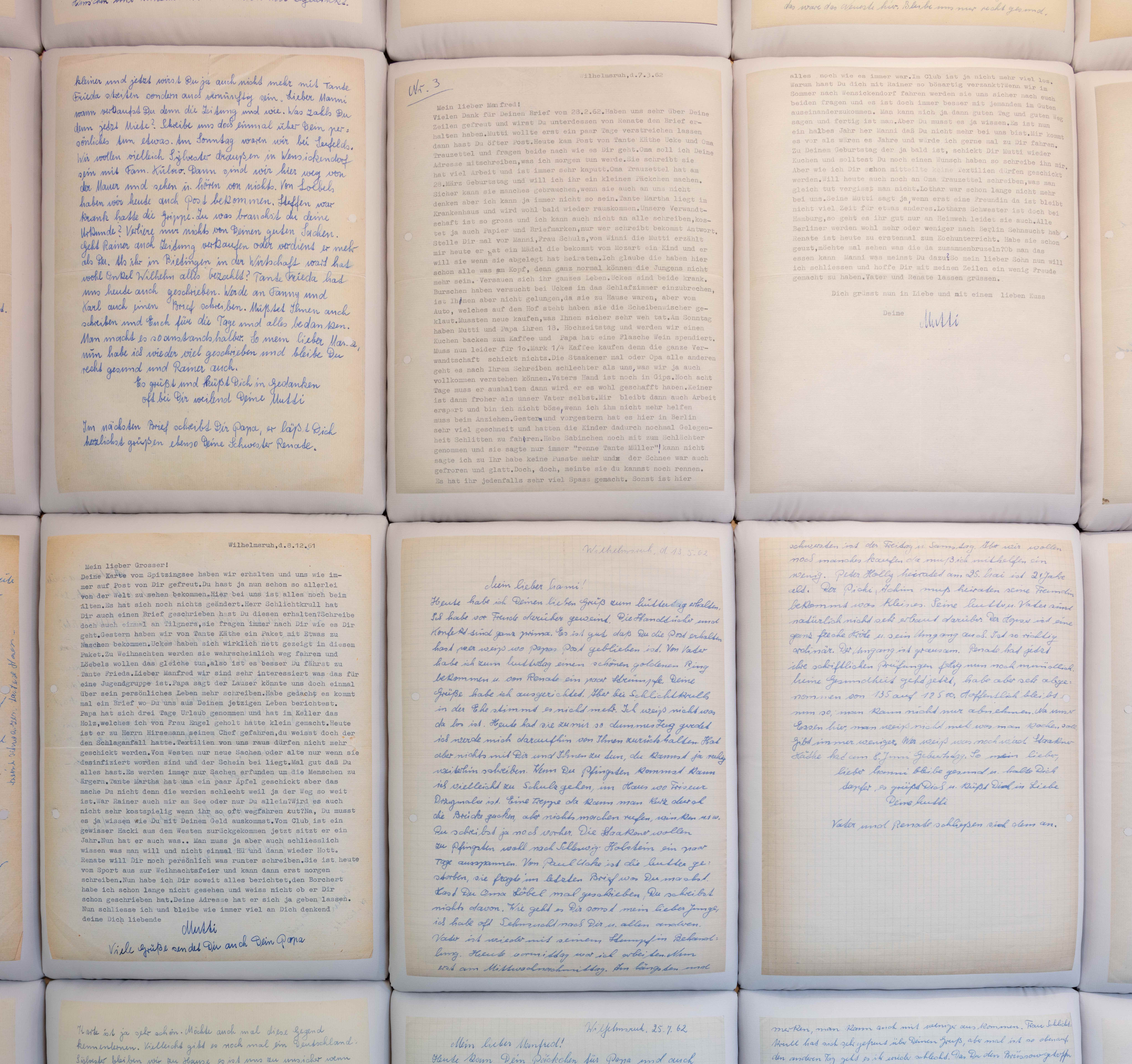 Seiten handgeschriebener Briefe und Notizen, ordentlich in Reihen angeordnet.