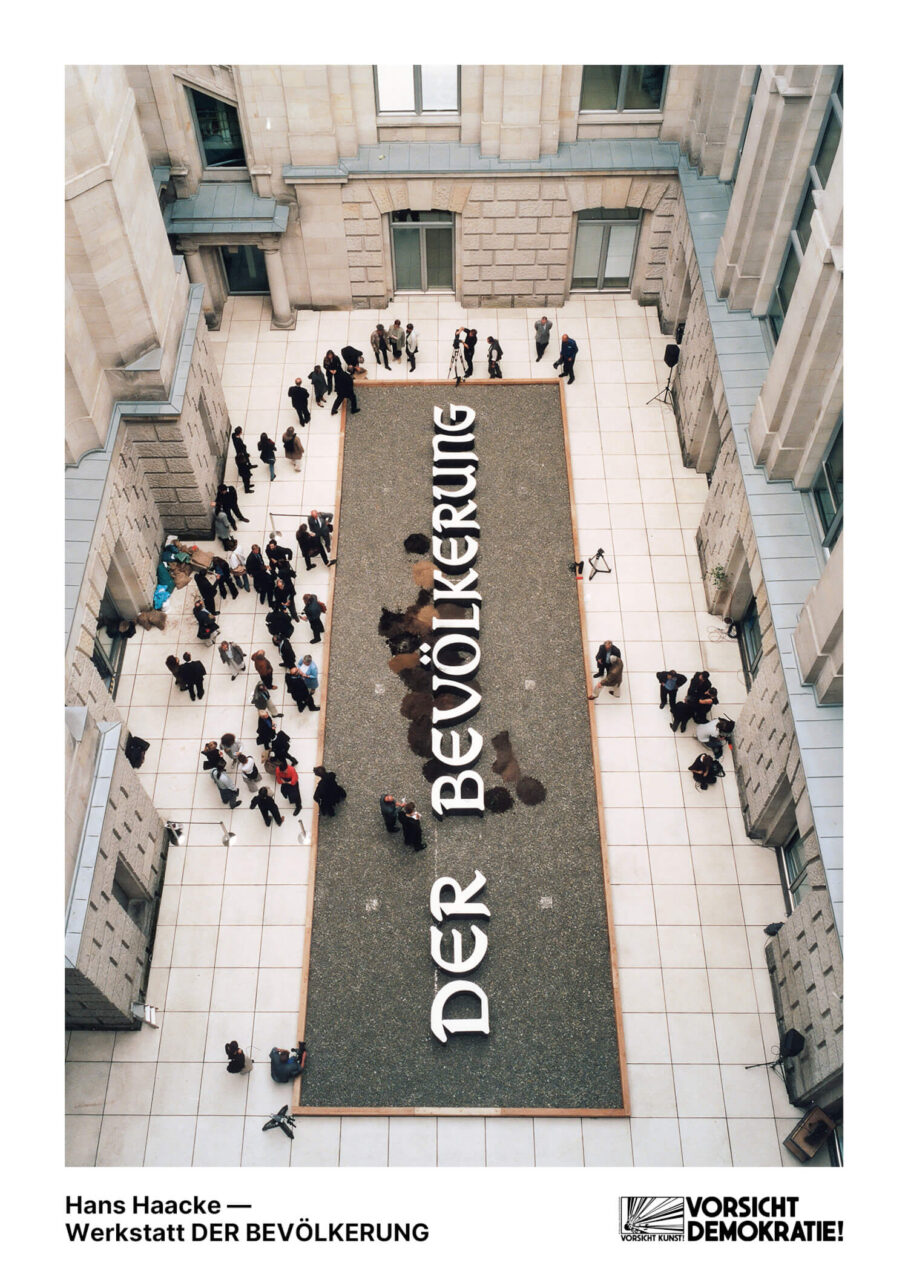 Installation von Hans Haacke mit dem Titel &bdquo;DER BEV&Ouml;LKERUNG&ldquo; in einem Innenhof, umgeben von Menschen und Medien.