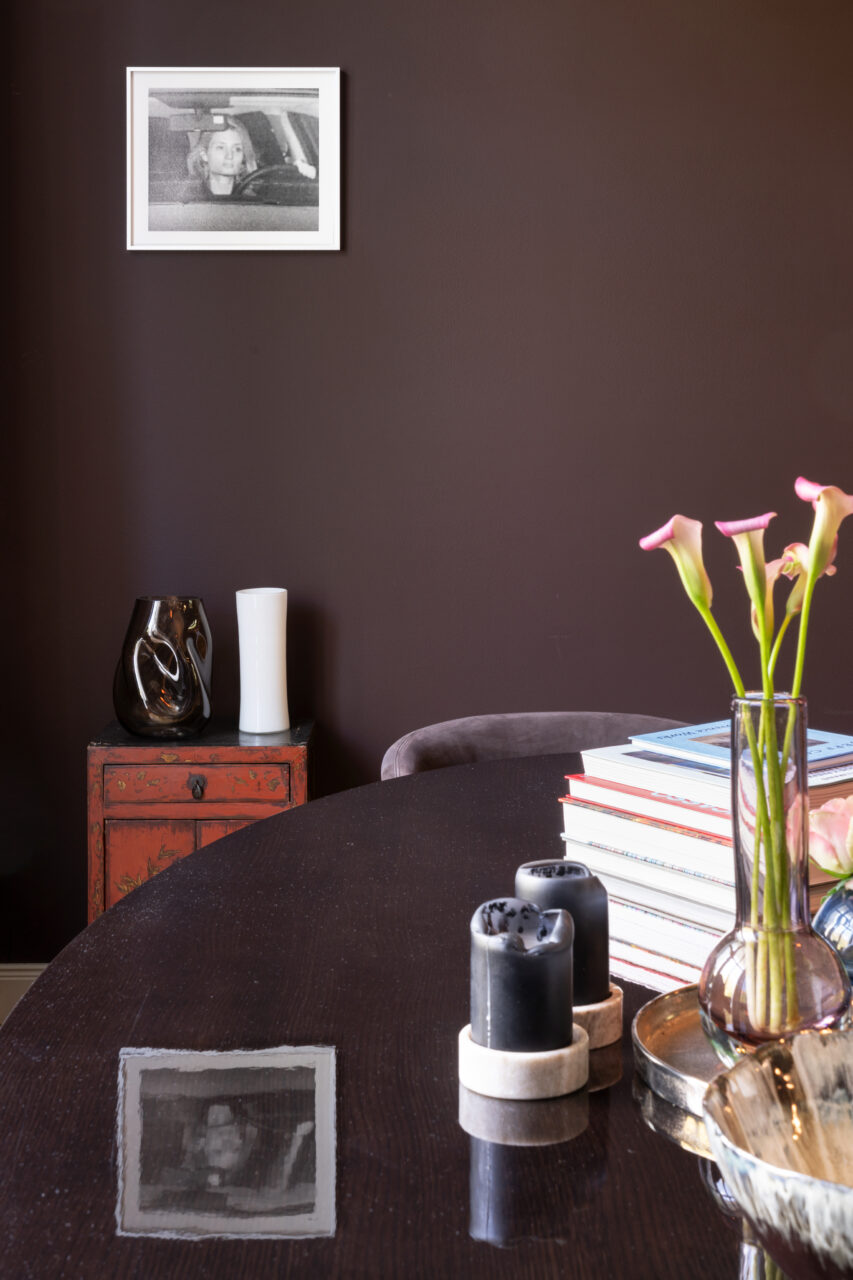Elegant room with a dark wall color, functional decor elements, and a reflective tabletop.